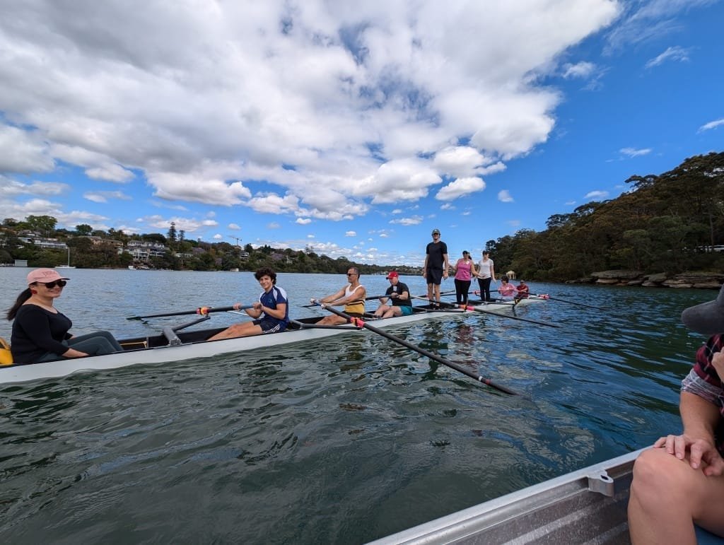 Members of the Learn to Row Squad standing in an eight on the water